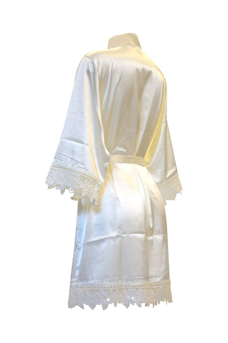 Vit sidenmorgonrock med spetsdetaljer bakifrån.